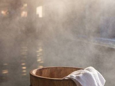 Bath bucket with a towel at blurred and fogged hot spring bath at Japanese onsen. Shot in the light of rising sun.